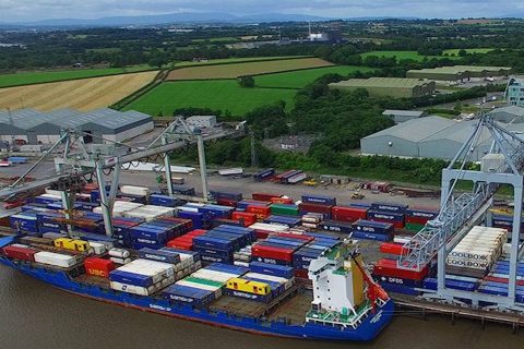 Container ship unloading at teh quayside in Waterford, seen from the air, looking inland at the green farmland