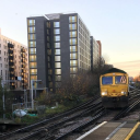 A freight train passes between tower blocks in London